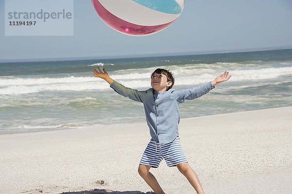 Junge spielt am Strand mit einem Ball
