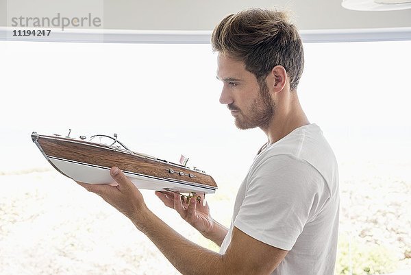 Junger Mann mit einem Modellboot