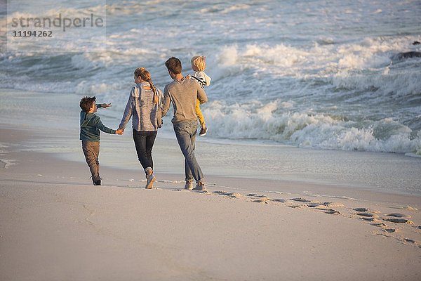 Rückansicht einer Familie beim Spaziergang am Strand
