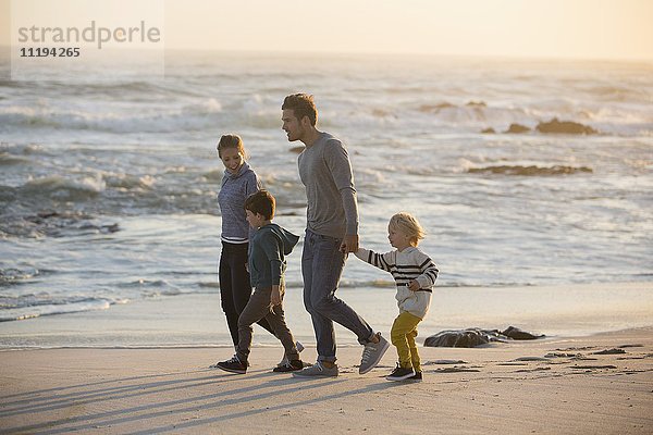 Profil einer Familie  die am Strand spazieren geht