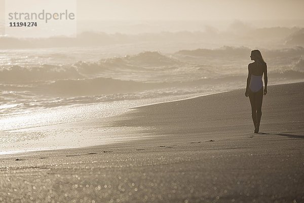 Junge Frau beim Spaziergang am Strand