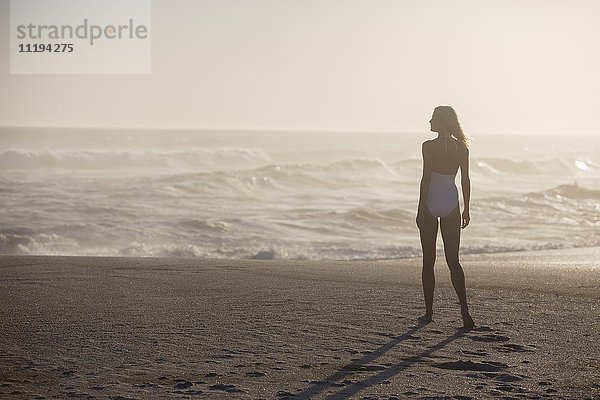 Rückansicht einer am Strand stehenden Frau