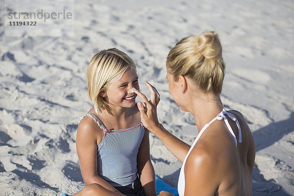 Frau mit Sonnenschutz auf der Nase ihrer Tochter