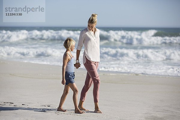 Profil einer Frau mit ihrer Tochter  die am Strand spazieren geht