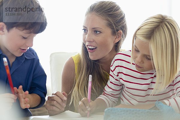 Glückliche Frau unterrichtet ihre Kinder zu Hause
