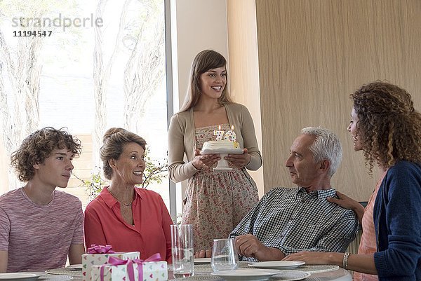Glückliche Großeltern feiern Geburtstag mit Enkelkindern zu Hause