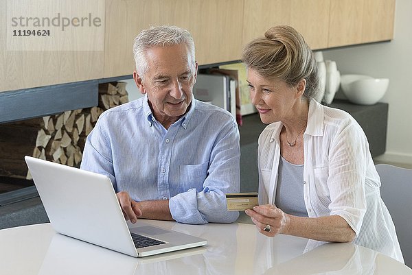 Senior Paar online einkaufen mit Laptop zu Hause