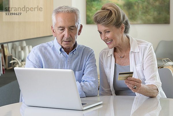 Senior Paar online einkaufen mit Laptop zu Hause