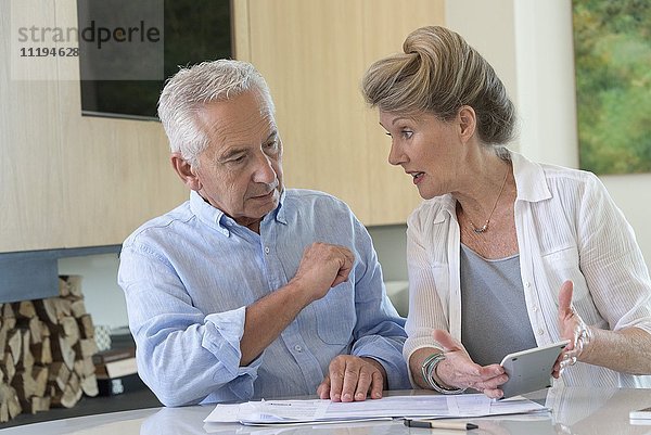 Seniorenpaar beim Sortieren von Rechnungen zu Hause