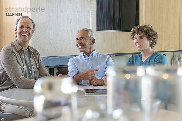 Glücklicher älterer Mann lächelnd mit Sohn und Enkel im Wohnzimmer