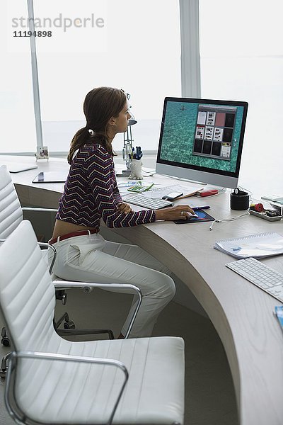 Profil einer Geschäftsfrau  die auf einem Desktop-PC im Büro arbeitet