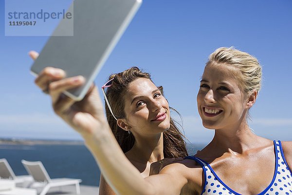 Glückliche Freunde  die Selfie mit einem digitalen Tablett nehmen