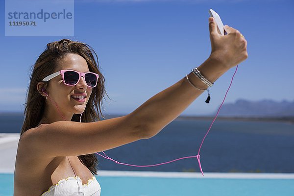 Nahaufnahme einer jungen Frau  die Selfie mit einem Smartphone nimmt.