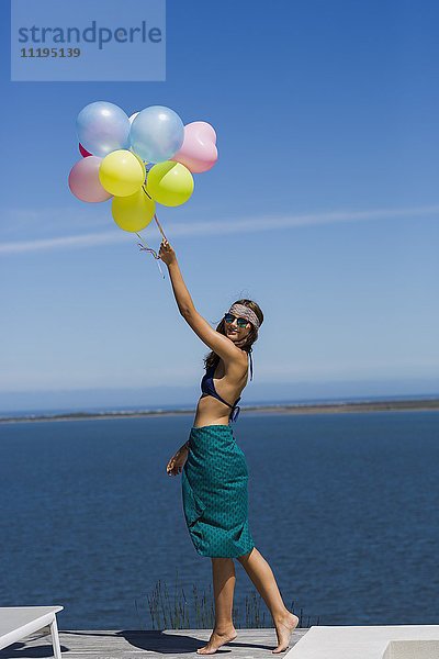Glückliche junge Frau mit Luftballons