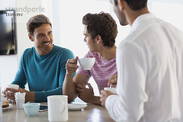 Drei männliche Freunde trinken Kaffee