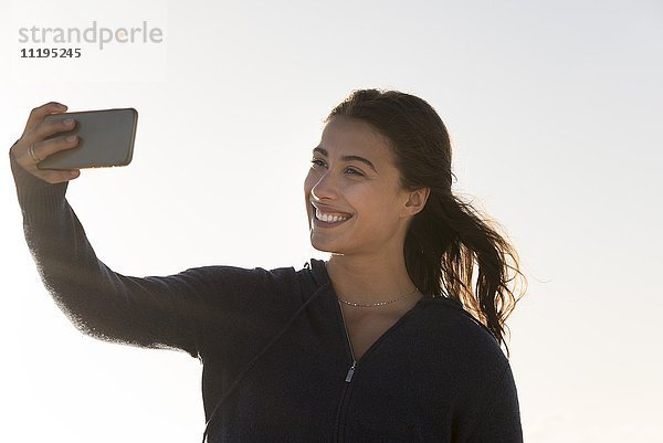 Glückliche Frau nimmt Selfie mit einem Smartphone
