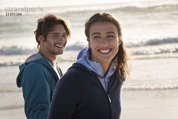 Glückliches junges Paar genießt am Strand