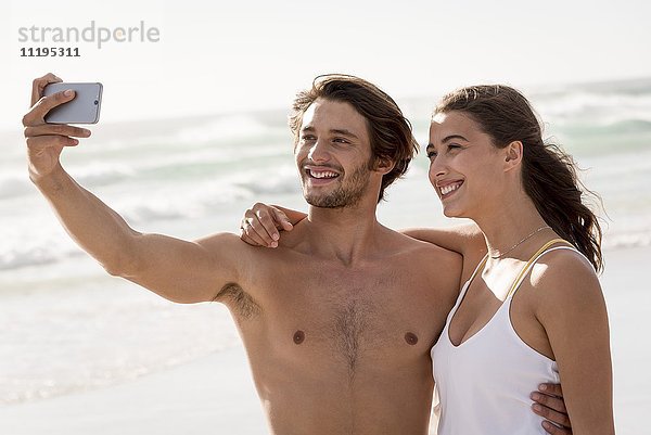 Junges Paar  das sich mit einem Smartphone von sich selbst befreien will