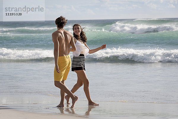 Ein glückliches junges Paar genießt den Strand