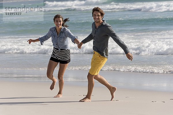 Porträt eines glücklichen jungen Paares am Strand