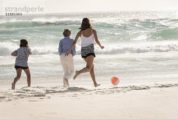 Glückliche Mehrgenerationen-Familie beim Spielen am Strand