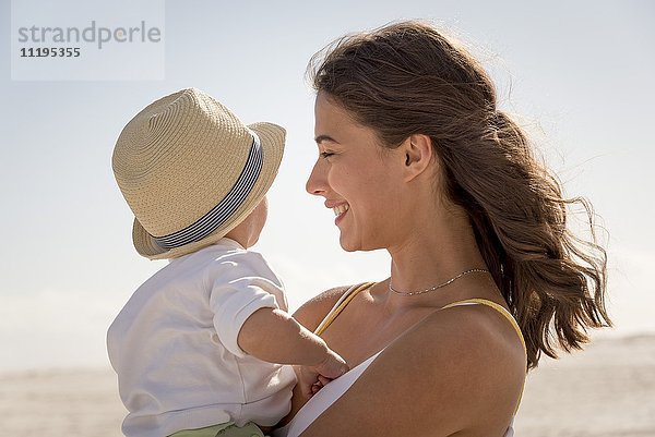 Glückliche Mutter mit ihrem kleinen Sohn am Strand