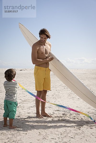 Glücklicher Vater und Sohn genießen am Strand