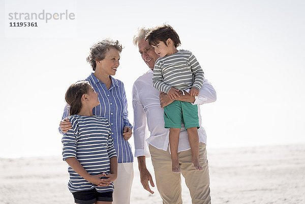 Zufriedene Großeltern mit Enkelkindern am Strand