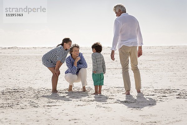 Zufriedene Großeltern mit Enkelkindern am Strand