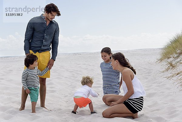 Glückliche junge Familie genießt am Strand