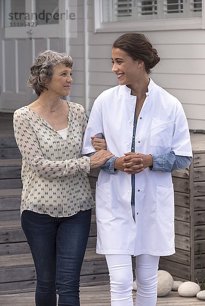Krankenschwester unterstützt ältere Frau im Pflegeheim