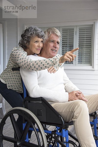 Senior im Rollstuhl mit seiner Frau auf der Veranda