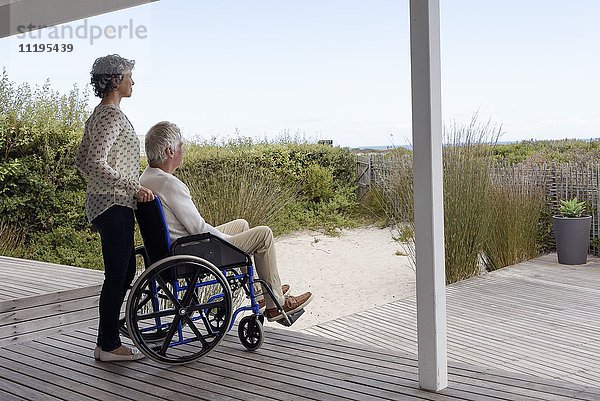 Senior im Rollstuhl mit seiner Frau auf der Veranda