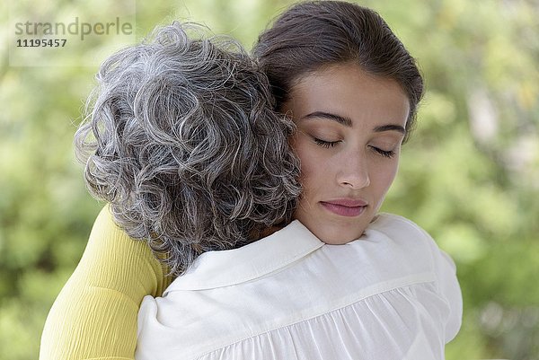 Liebevolle Mutter umarmt ihre erwachsene Tochter.