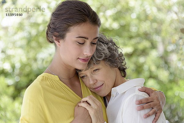Liebevolle junge Frau  die ihre Mutter umarmt.