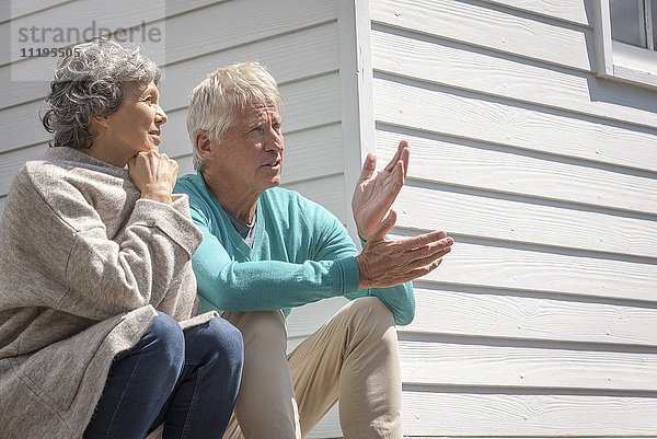 Seniorenpaar im Gespräch vor dem Haus