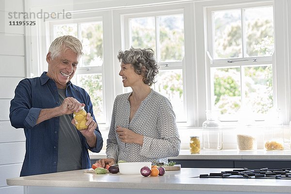Fröhliches Seniorenpaar bei der Zubereitung des Essens in der Küche