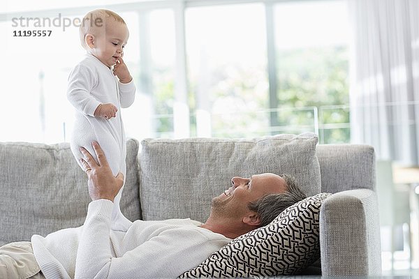 Glücklicher Vater spielt mit seiner süßen kleinen Tochter zu Hause.