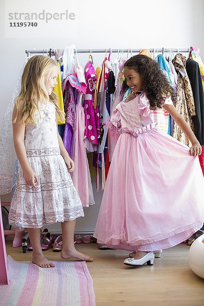 Zwei kleine Mädchen  die Kleidung anprobieren.