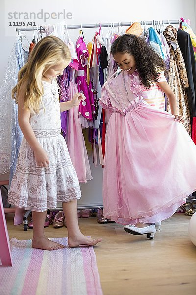 Zwei kleine Mädchen  die Kleidung anprobieren.