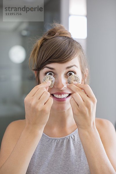 Porträt einer schönen Frau mit Teebeuteln vor den Augen