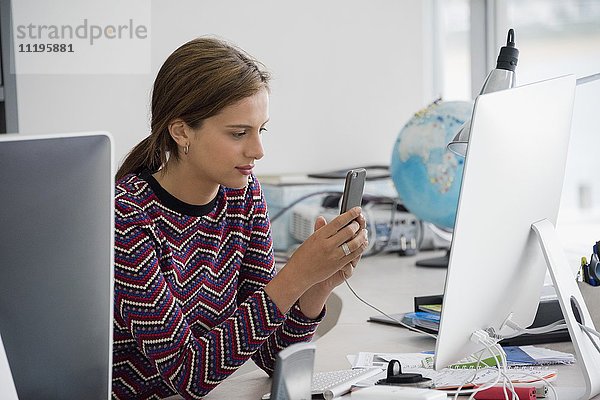 Seitenprofil einer Geschäftsfrau mit Handy im Büro