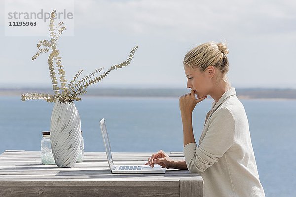 Seitenprofil einer schönen Frau mit einem Laptop