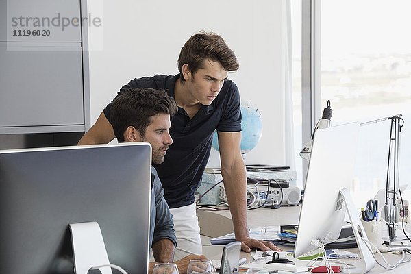 Zwei Geschäftsleute  die am Computer im Büro arbeiten