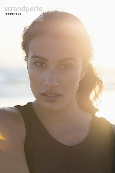 Porträt einer schönen jungen Frau am Strand stehend