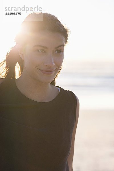 Schöne junge Frau am Strand stehend