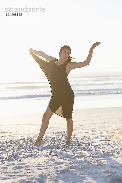 Attraktive junge Frau posiert am Strand
