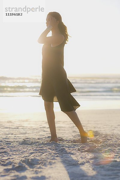 Attraktive junge Frau beim Spaziergang am Strand