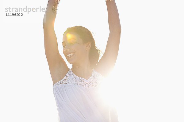 Schöne junge Frau  die am Strand posiert.