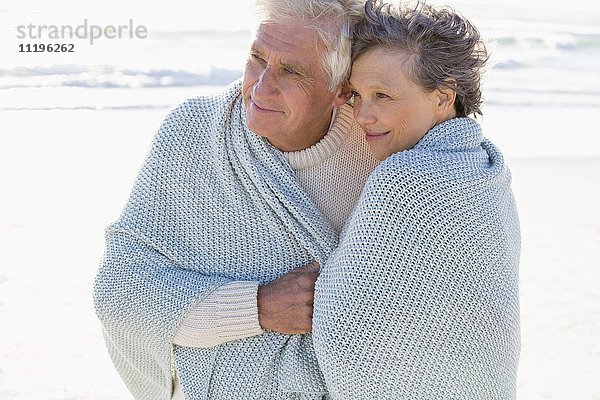 Altes Paar umarmt sich am Strand